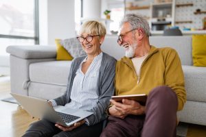 Happy romantic senior couple researching retirement mortgage quotes at home